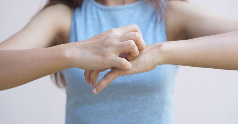 Prurito alle mani ragazza si gratta le mani