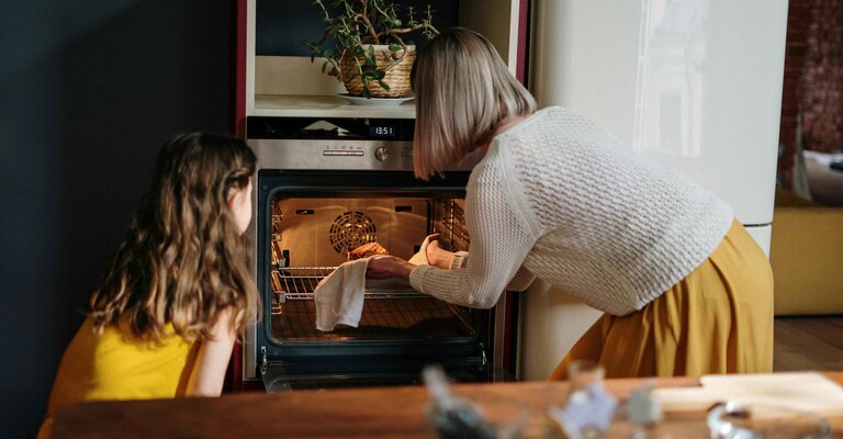 Mamma e figlia cucinano al forno