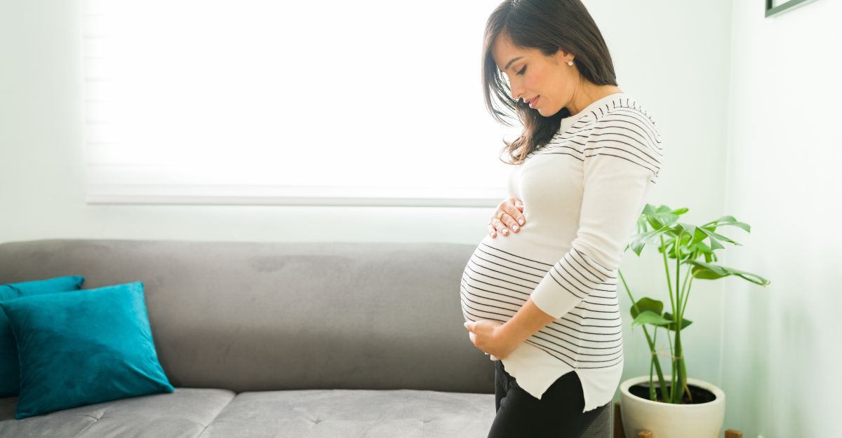 donna incinta in piedi in salotto