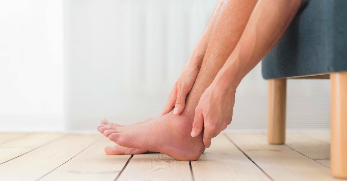 Uomo si massaggia le caviglie gonfie dolenti