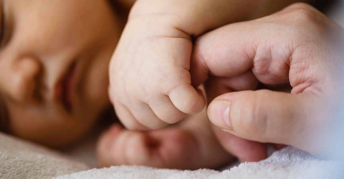 neonato stringe il dito di un adulto