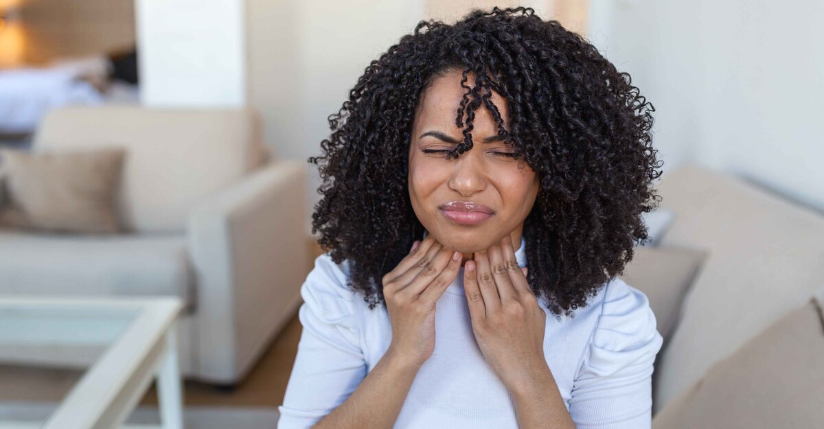 Donna sofferente si tocca il collo