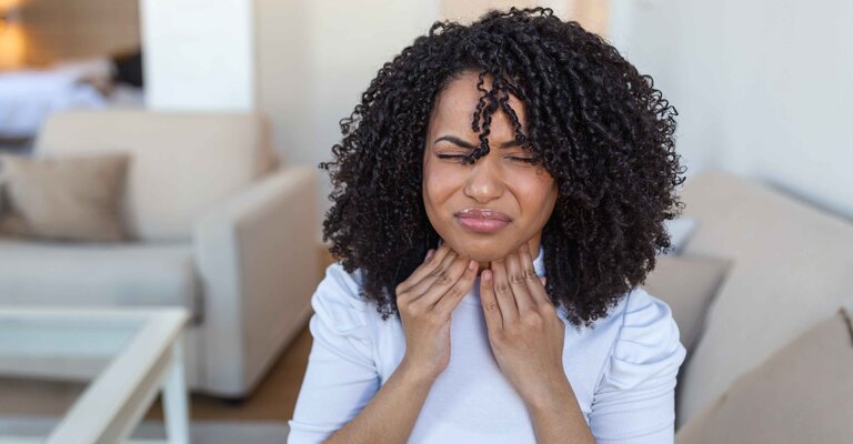 Donna sofferente si tocca il collo