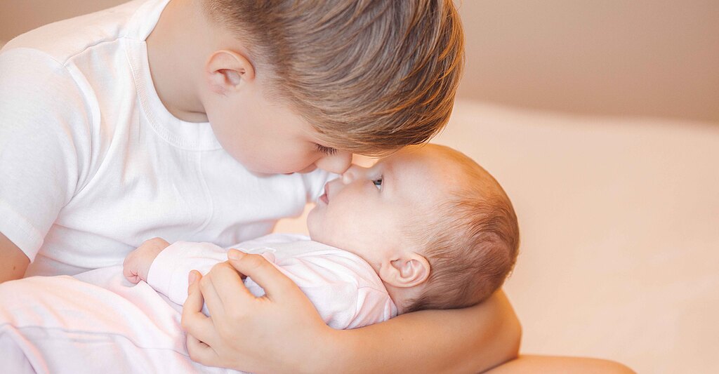 Bambino primogenito abbraccia il fratello neonato