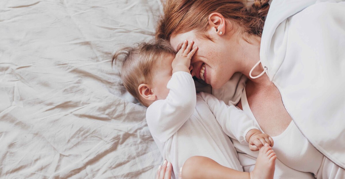 Donna abbraccia suo figlio sdraiata a letto