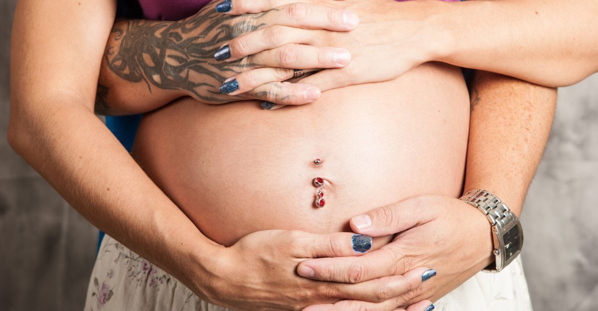 donna incinta con piercing all'ombelico