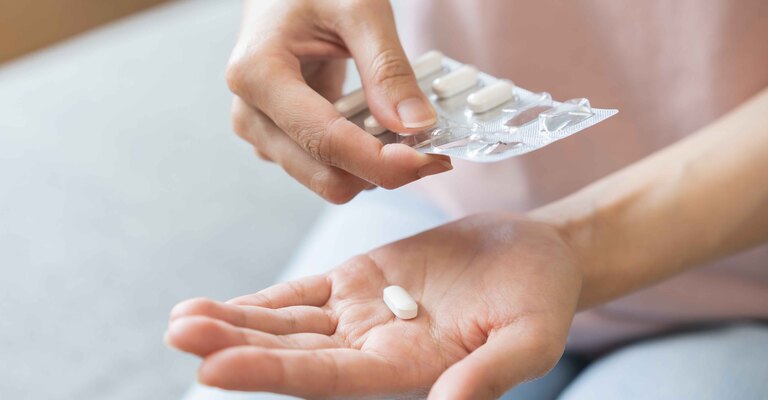 Donna prende una pastigli di cortisone