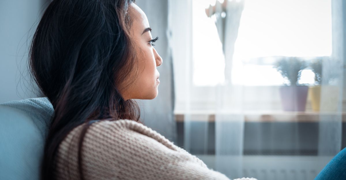donna pensierosa guarda fuori dalla finestra