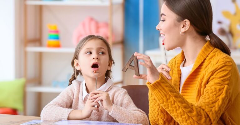 bambina impara a leggere con la maestra