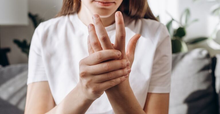 ragazza si tocca le dita intorpidite