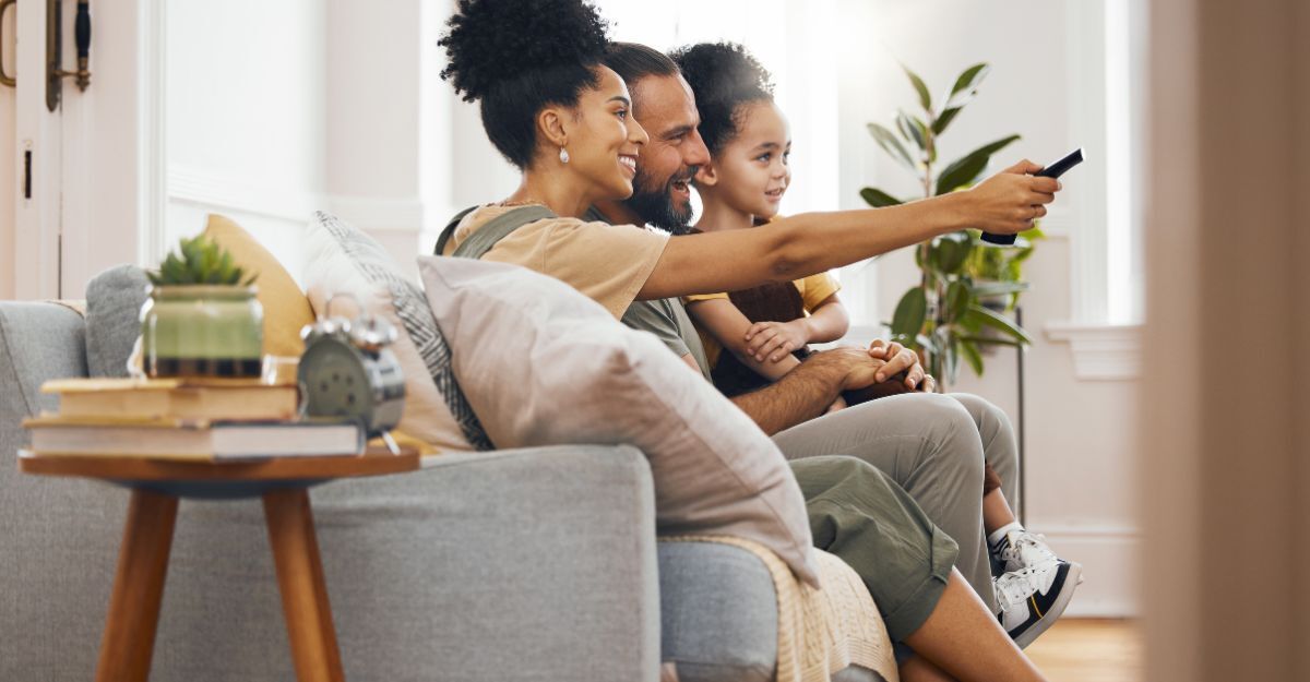 famiglia guarda la tv sul divano