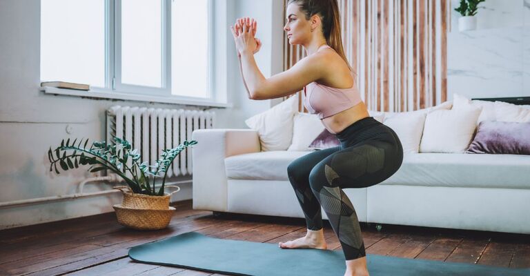 ragazza fa squat nel salotto