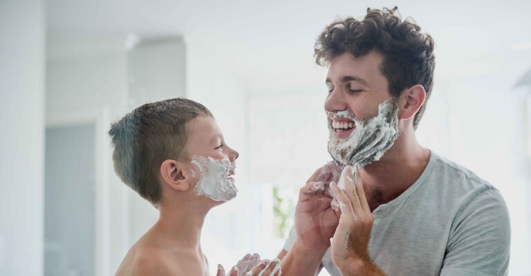 Bambino si applica la schiuma da barba insieme al padre