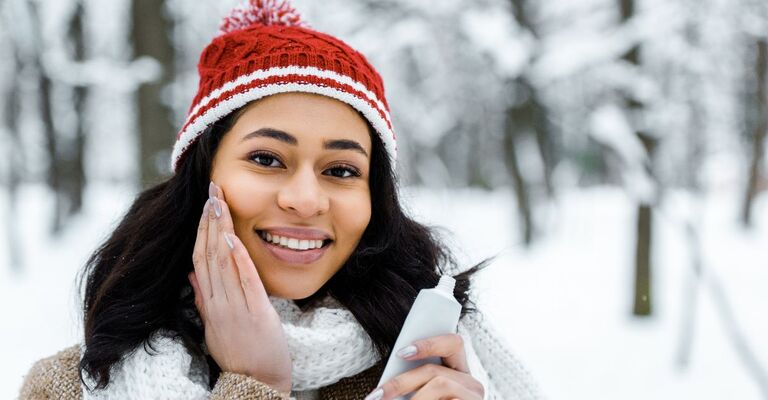 donna-in-veste-invernale-che-si-mette-la-crema