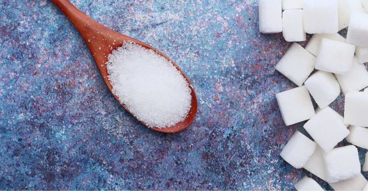 Cucchiaio di zucchero con zollette al lato
