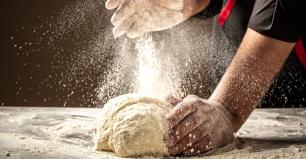 Persona che impasta una pizza con la farina