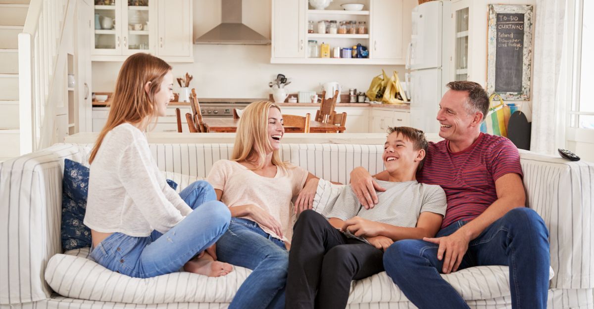 figli e genitori ridono sul divano