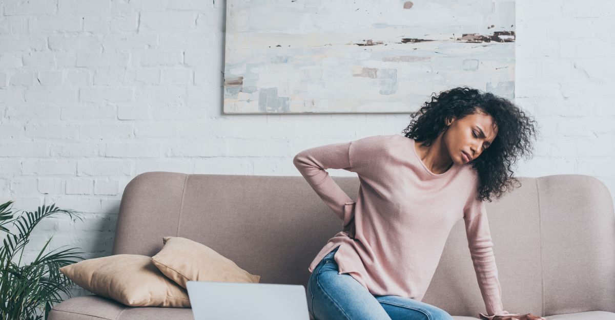 donna con mal di schiena sul divano