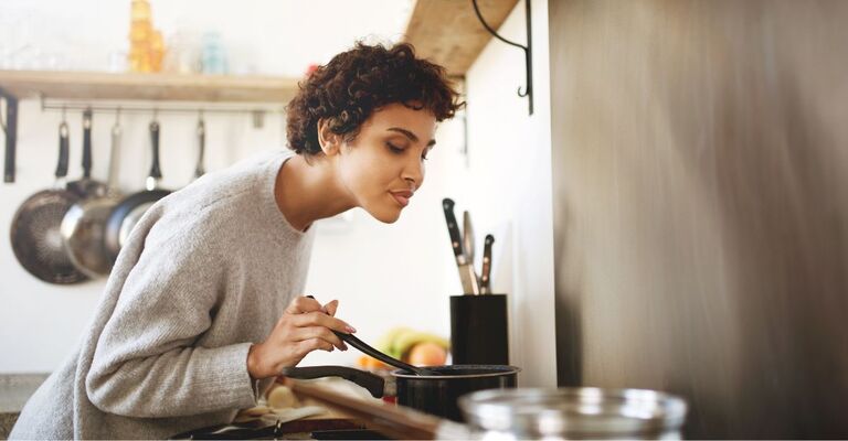 Ragazza controlla pentola mentre cucina
