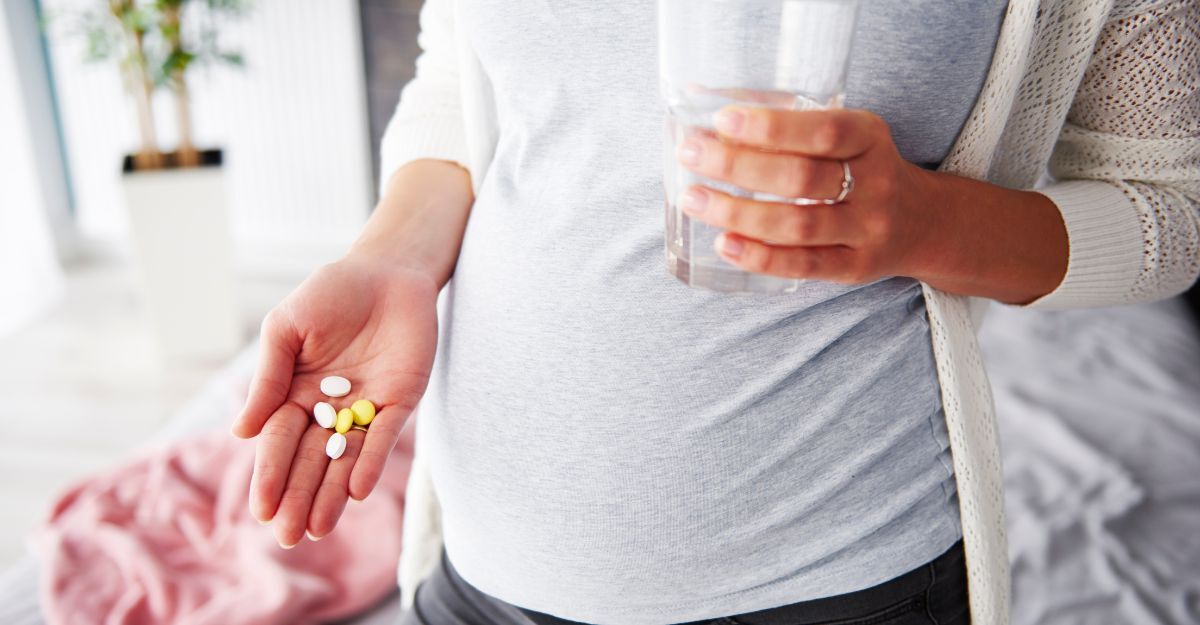 Donna incinta con pastiglie e acqua