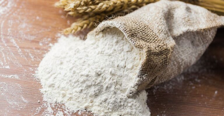 Sacco di farina aperto sul tavolo
