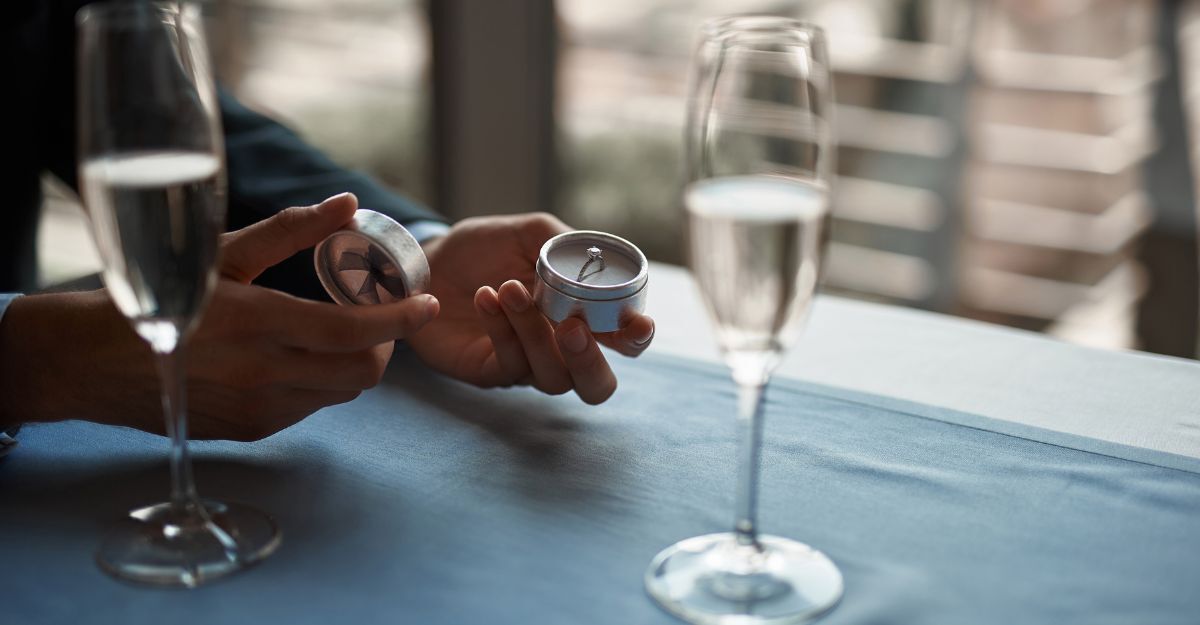 Mano che apre scatola con anello 