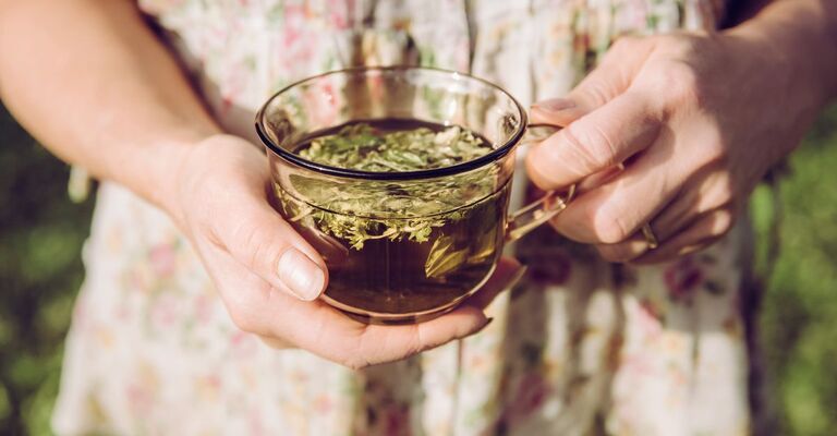 donna tiene una tazza di tisana in mano