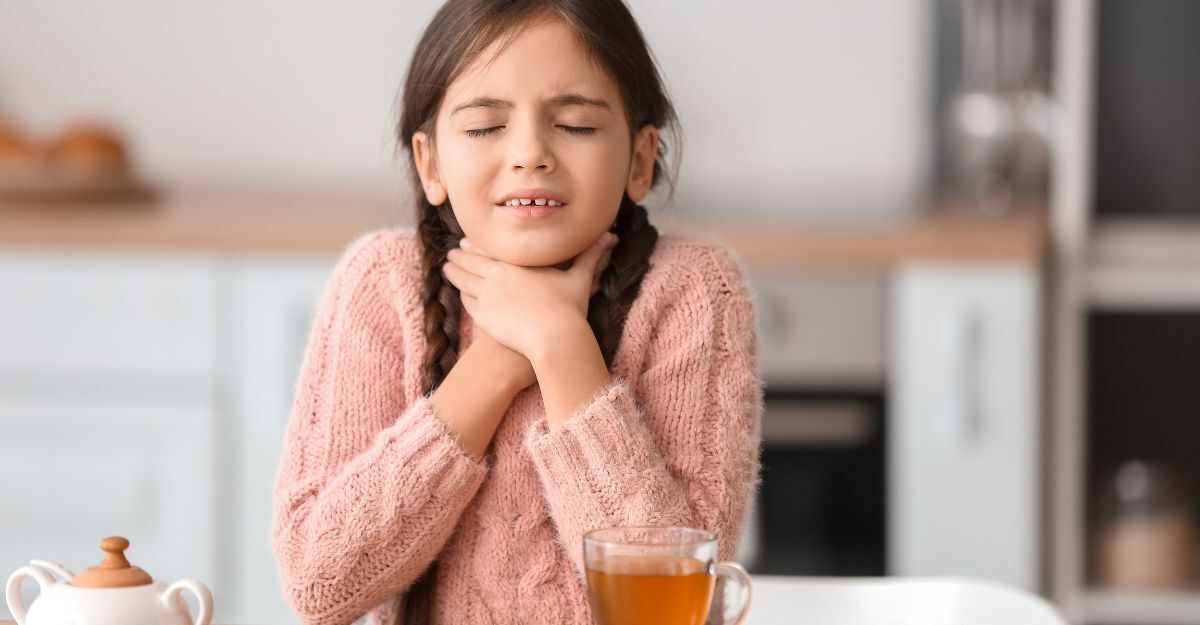 Bambina si tocca la gola dolorante