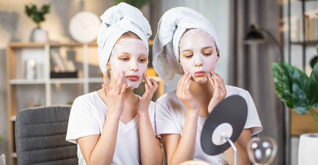 Due ragazze si guardano allo specchio mentre fanno una maschera di bellezza