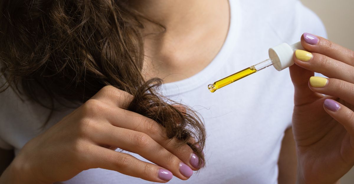 Pipetta di olio su capelli ricci applicato da una ragazza riccia