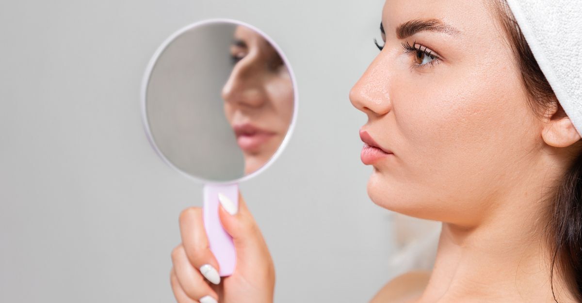 Ragazza con naso aquilino e specchio in mano