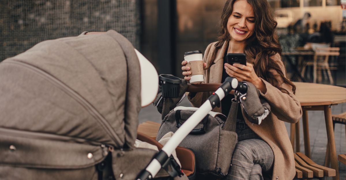 donna con neonato in carrozzina, beve il caffè