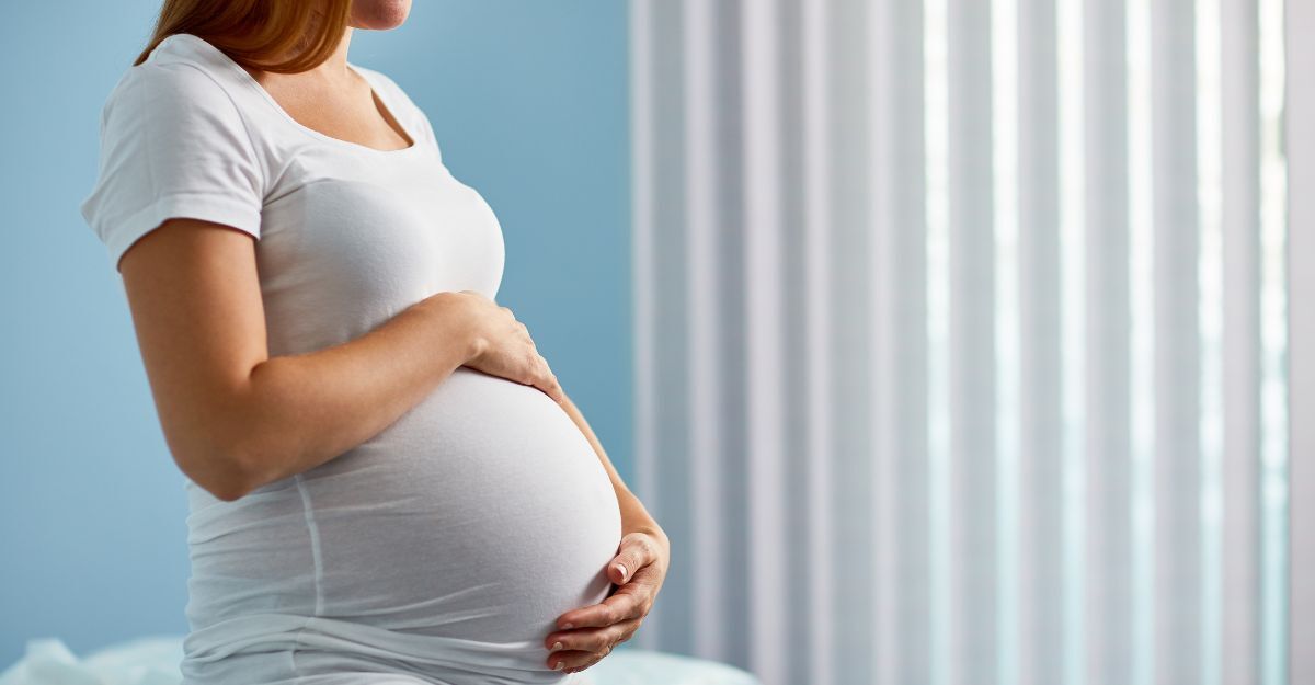 Una donna in gravidanza seduta su un lettino di ospedale