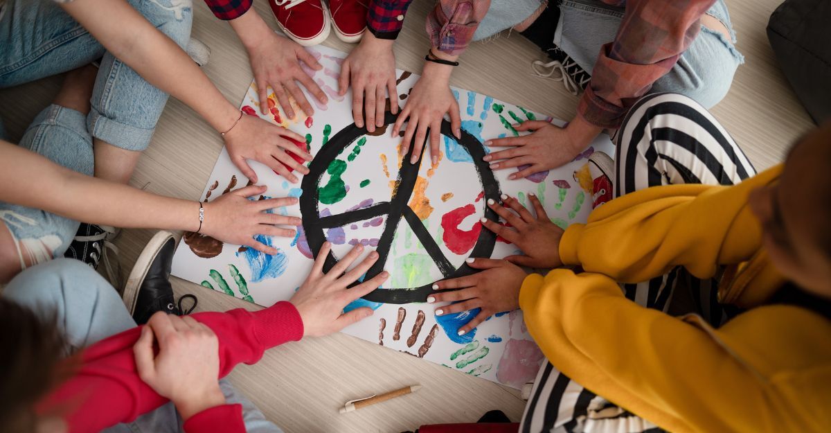 mani di bambini sopra il disegno del simbolo della pace