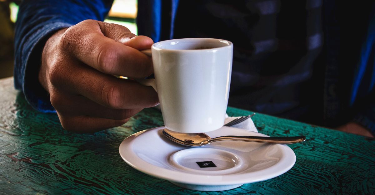 Mano di uomo tiene in mano una tazzina di caffè