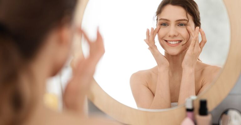 ragazza fa skin care davanti allo specchio