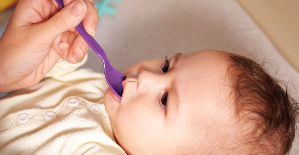 Neonato beve da un cucchiaino