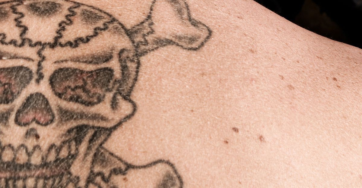 Un ragazzo con un teschio tatuato sulla schiena