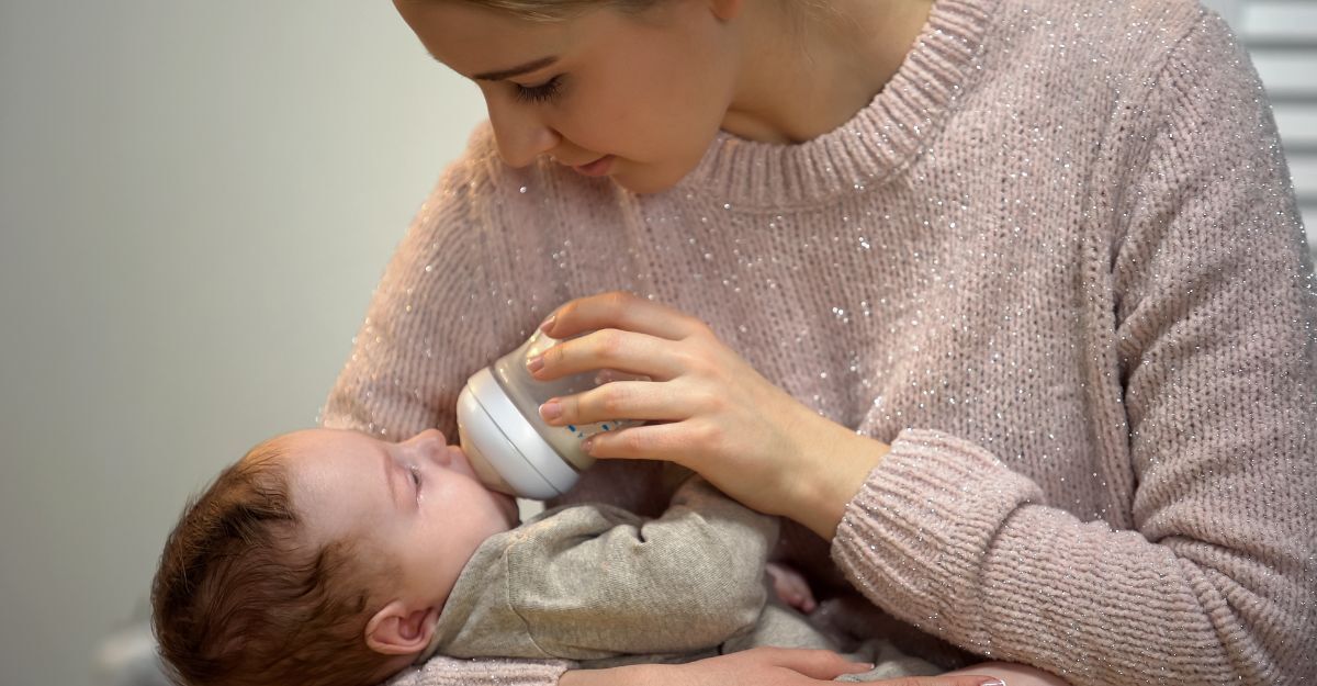 Un neonato beve del latte dal biberon