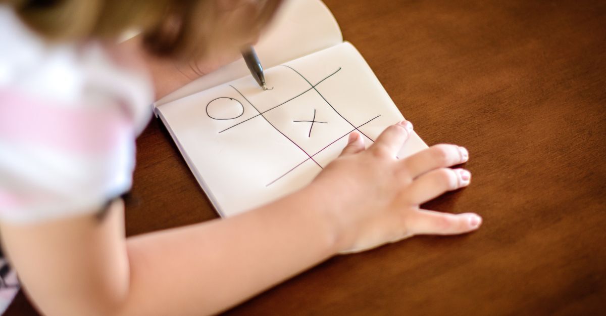 Bambina gioca a tris su un foglio di carta