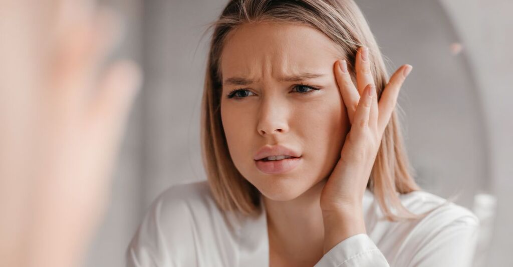 ragazza davanti allo specchio corruga la fronte