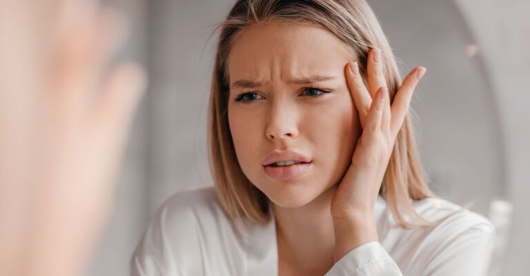 ragazza davanti allo specchio corruga la fronte