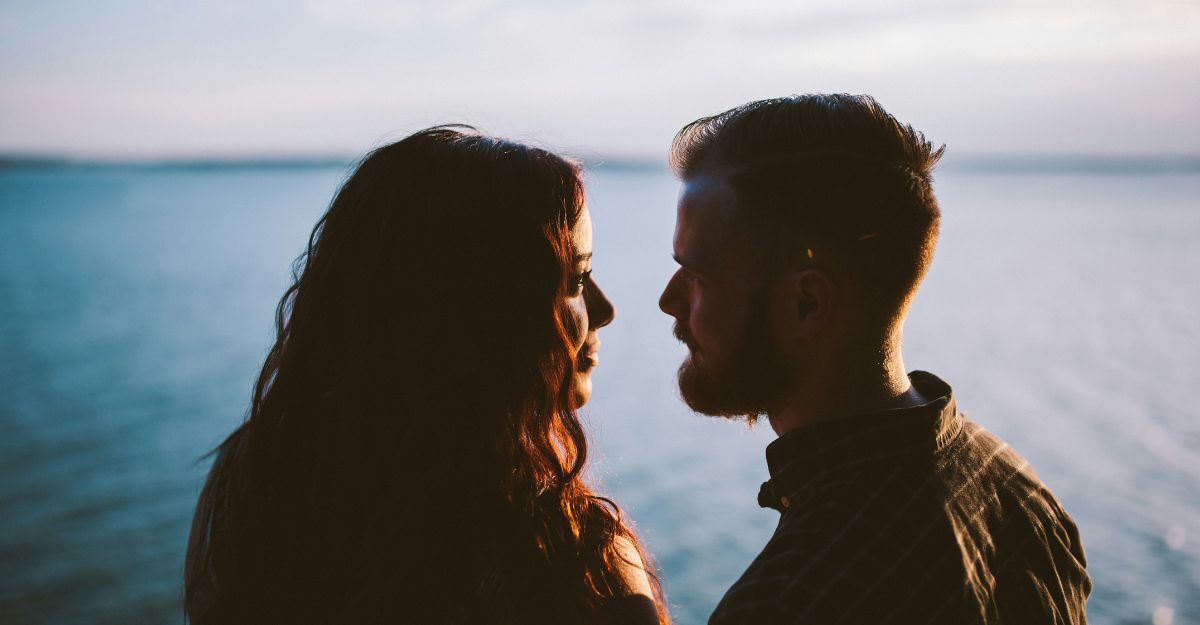 Un ragazzo e una ragazza si guardano intensamente davanti al mare