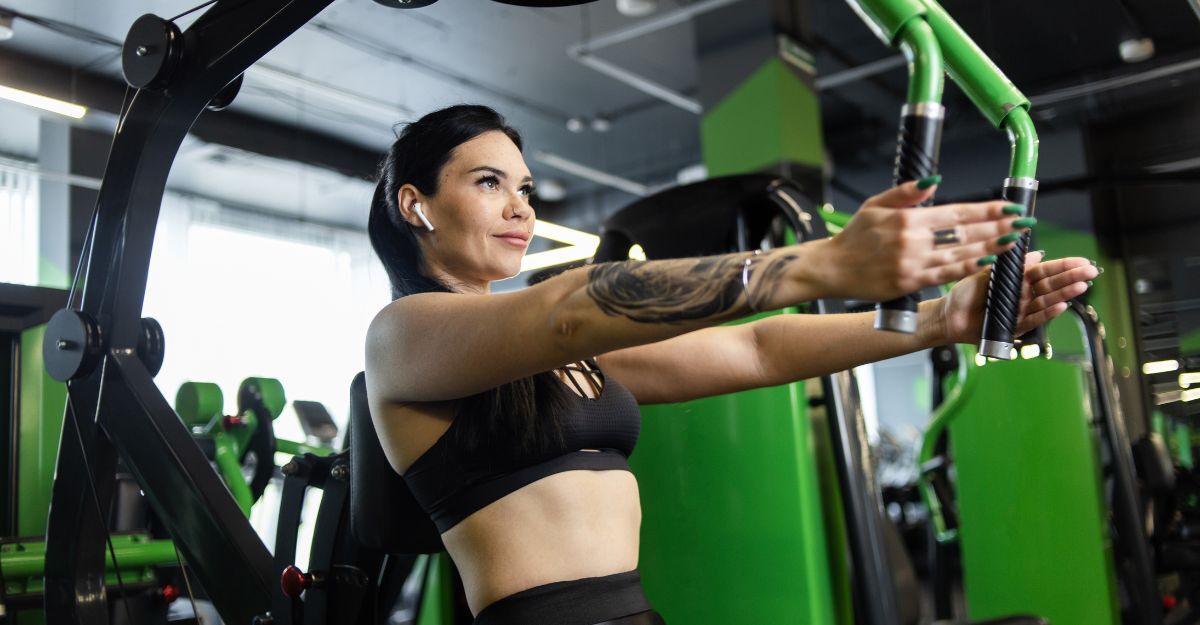 Donna si allena in palestra con la pectoral machine