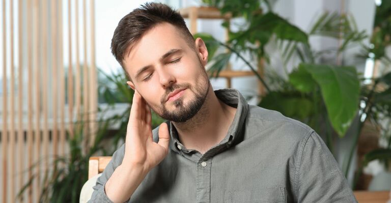 Uomo si tocca una parte della testa dolorante