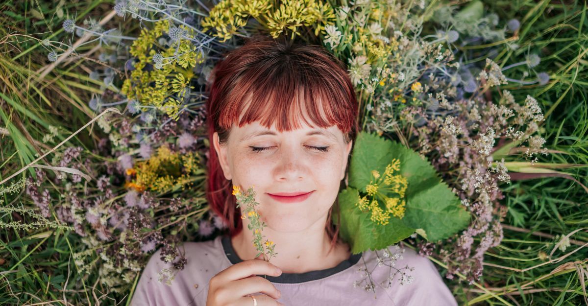 Ragazza sdraiata su un prato sorride felice