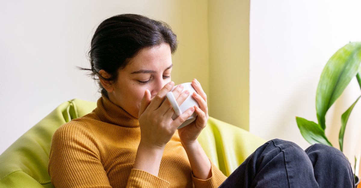 Una ragazza sul divano beve una tisana