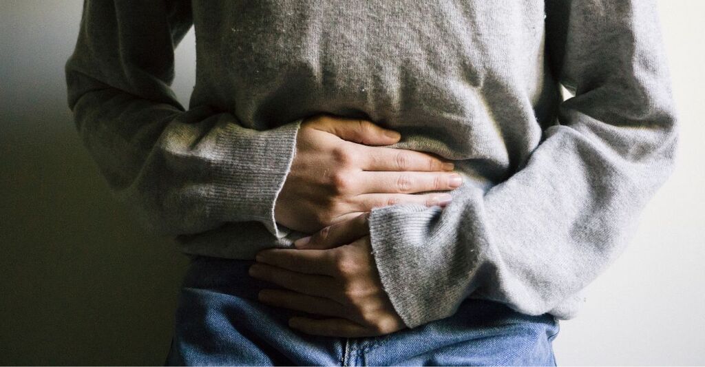 Donna con mani sul ventre