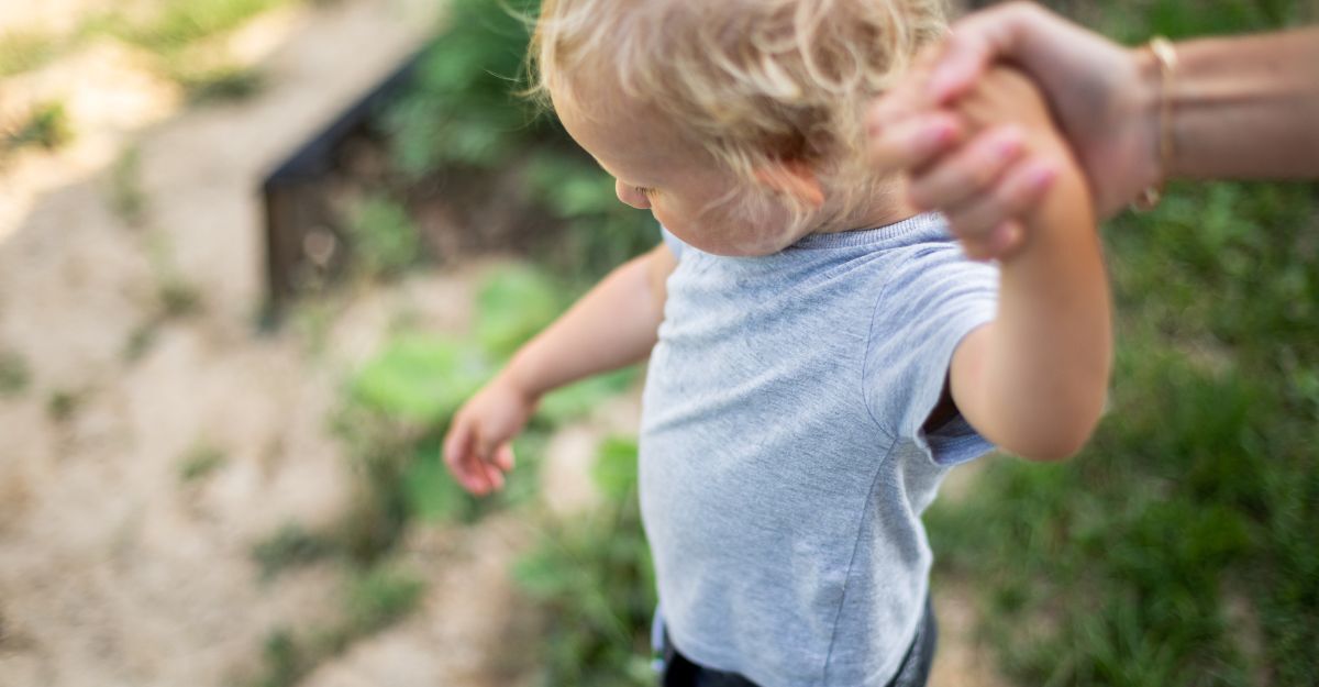 Un bambino cammina mano nella mano con un genitore