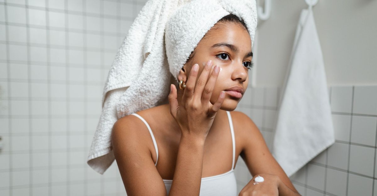 Ragazza con turbante in testa si applica la crema viso 